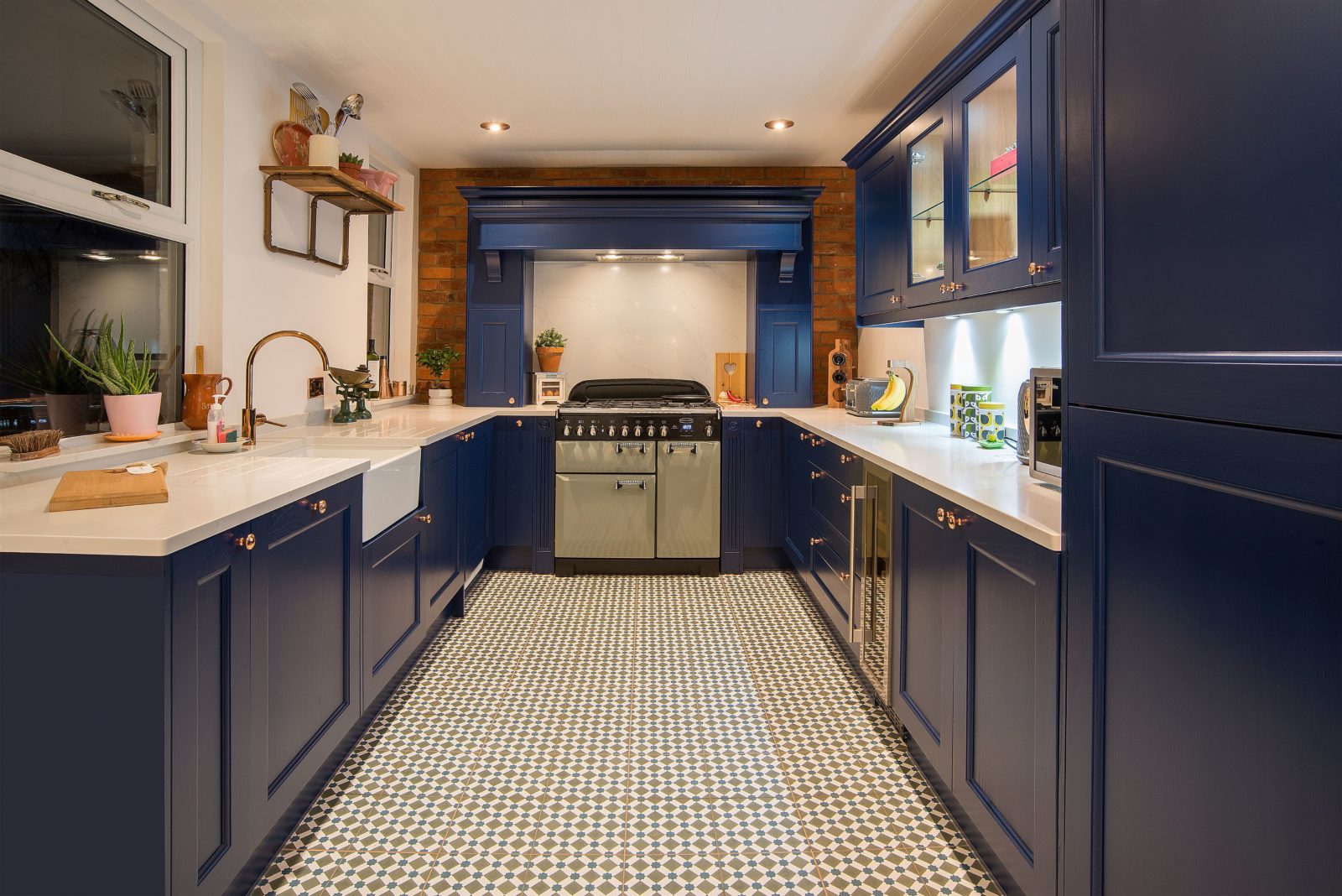 Luxury kitchen with navy blue cabinets, white countertops, and patterned floor tiles