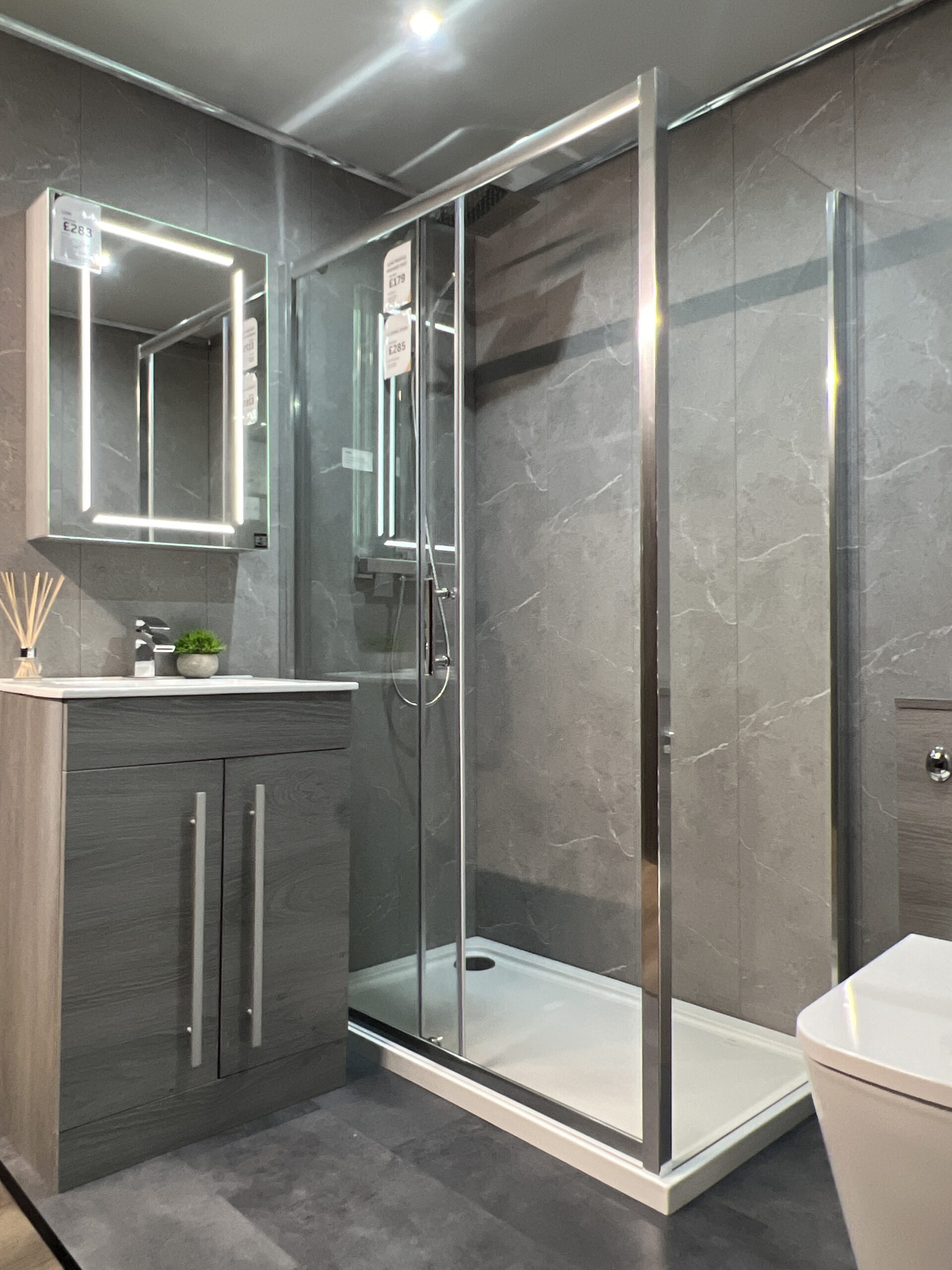 Modern bathroom with grey marble-effect tiles and walk-in shower enclosure